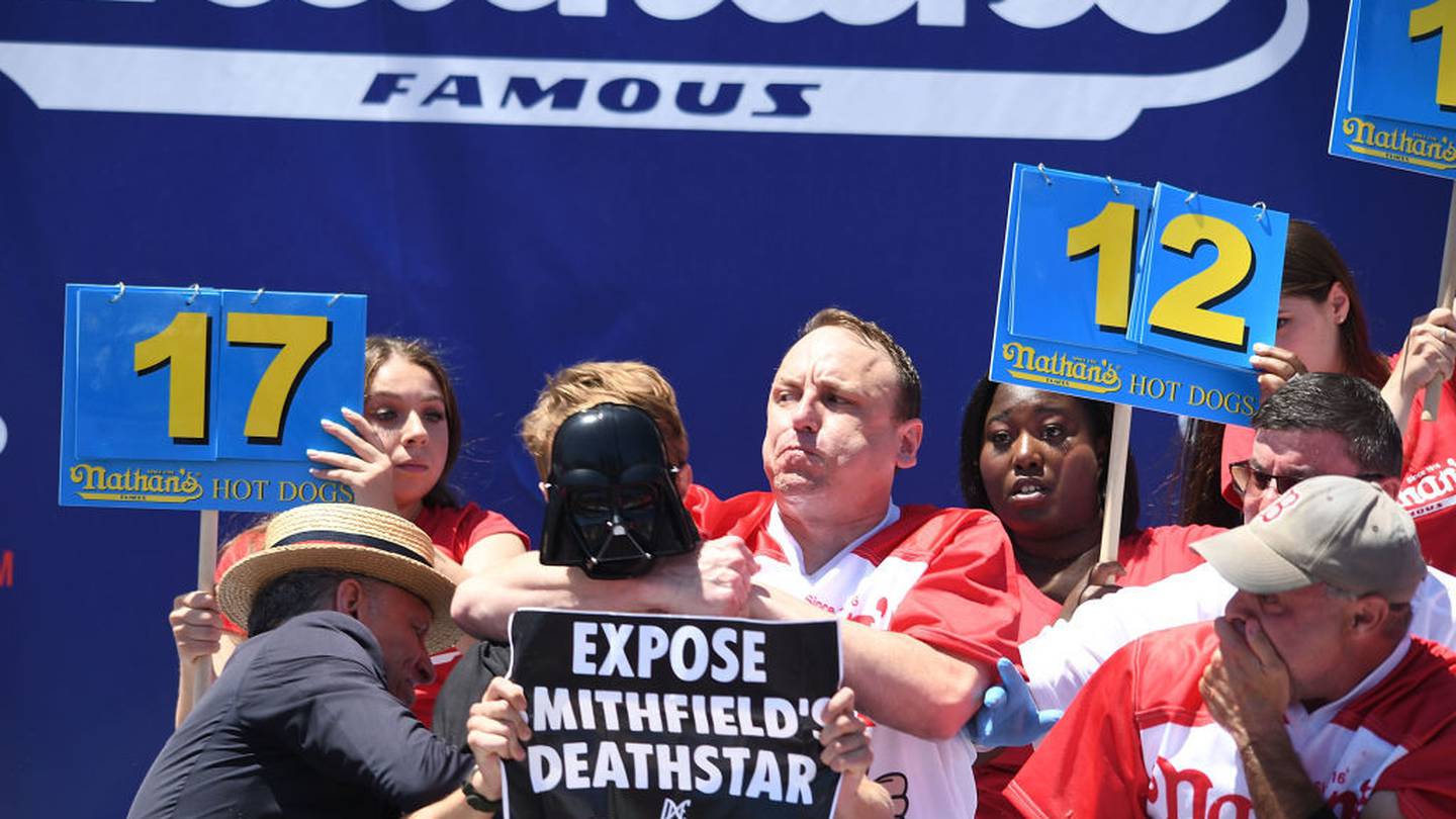 Hot dog-eating champ stops protestor mid-bite